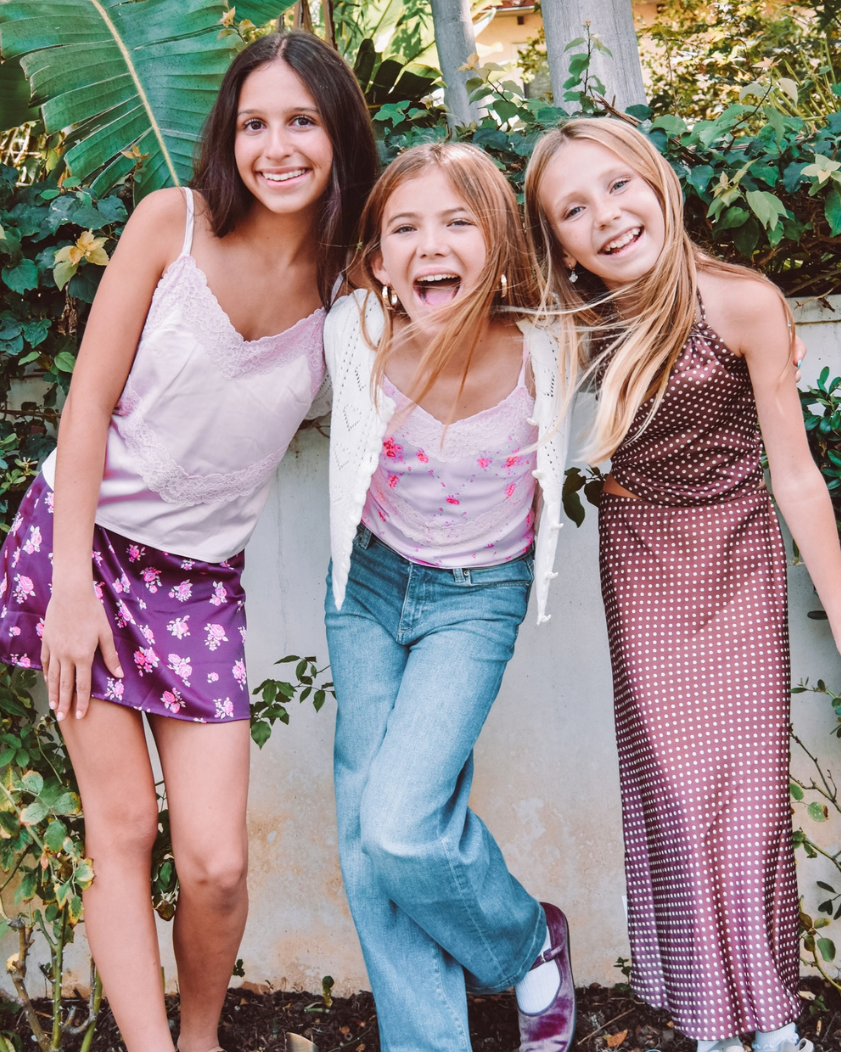 Three girls smiling and laughing in fabulous fall outfits.